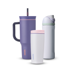 Owala All Day Bundle showing three bottles — a deep purple 40oz Tumbler with side handle, peach pink accent ring, and dark purple straw, a small white insulated cup with pink accent ring, and a white FreeSip with mint green accent band, lavender flip cap, and matching lavender carry loop